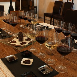 dégustation de vins rouge et blanc accompagnés de chocolats sur une table en bois